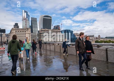 London, Großbritannien. 27. September 2022 Fußgänger, die auf der London Bridge mit der Skyline der Stadt London im Hintergrund laufen. Die Bank of England hat angekündigt, dass sie bereit ist, durch Anhebung der Zinssätze zu intervenieren, um das kämpfende Pfund, das gegenüber dem US-Dollar ein Allzeittief erreichte, zu stützen. Kredit: amer ghazzal/Alamy Live Nachrichten. Stockfoto