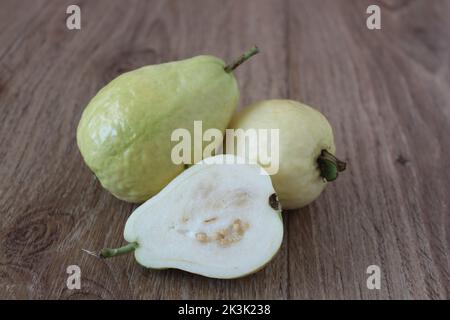 Guava Obst, schneiden Sie frische weiße Guava auf Holztisch. Köstliche und saftige Früchte. Nahaufnahme, Sitzansicht. Stockfoto
