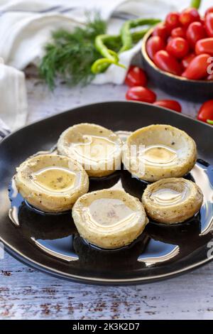 Artischocken mit Olivenöl. Baby Artischocken auf Holz Hintergrund. Mediterrane Küche. Nahaufnahme Stockfoto