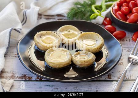 Artischocken mit Olivenöl. Baby Artischocken auf Holz Hintergrund. Mediterrane Küche. Nahaufnahme Stockfoto