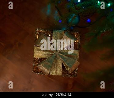 Nahaufnahme von Weihnachtsgeschenk-Box, elektrischen blauen Girlanden, Tannenzweig und Weihnachtsbaum Dekoration. Stockfoto