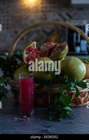 Korb mit Granatapfel und Granatapfelsaft in der Küche Stockfoto