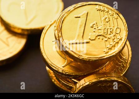 Schokoladenmünze. Hintergründe von Schokolade Euro-Münze Geld auf braunem Hintergrund. Euro-Münzen übereinander gestapelt in verschiedenen Positionen. Eine Gruppe von Münzen. Stockfoto