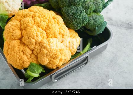 Colorfu-Blumenkohl. Verschiedene Arten von Blumenkohl auf grauem Beton Hintergrund. Violette, gelbe, weiße und grüne Farbkabbage. Brokkoli und Romanesco. Stockfoto