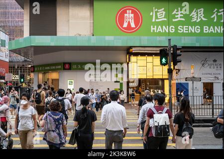 Fußgänger werden gesehen, wie sie die Straße vor dem in Hongkong ansässigen Banken- und Finanzdienstleistungsunternehmen Hang Seng Bank, einer Zweigstelle in Hongkong, überqueren. Stockfoto