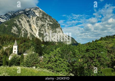 Die Pfarrkirche im kleinen Dorf Purgg und Grimming Peak in der Steiermark, Österreich Stockfoto