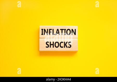 Symbol für Inflationsschocks. Konzept Worte Inflation Schocks auf Holzblöcke. Schöne gelbe Tabelle gelben Hintergrund. Die Inflation der Unternehmen erschüttert das Konzept. Stockfoto