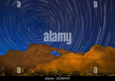 Star Trails drehen sich um den North Star über Skyline Arch bei Nacht im Arches National Park, Moab, Utah. Stockfoto