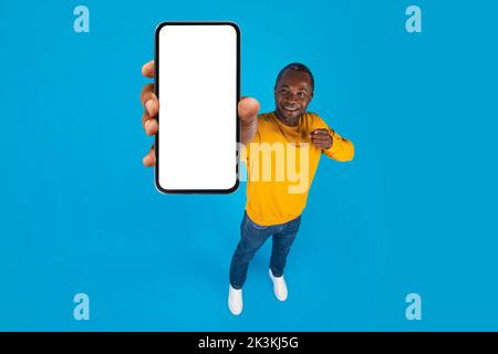 Glücklicher afroamerikanischer Mann, der Handy zeigt, Nachbau Stockfoto