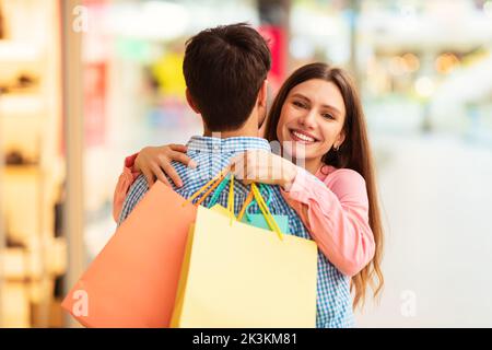 Glückliche Frau Umarmte Ehemann Und Genoss Das Gemeinsame Einkaufen In Der Modernen Mall Stockfoto