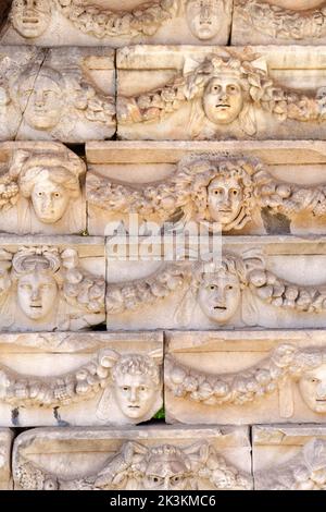 Friesen auf dem Tiberius-Portikus, in dem verschiedene Götter, Göttinnen und Porträtköpfe in Aphrodisias, Aydin, Türkei, abgebildet sind Stockfoto