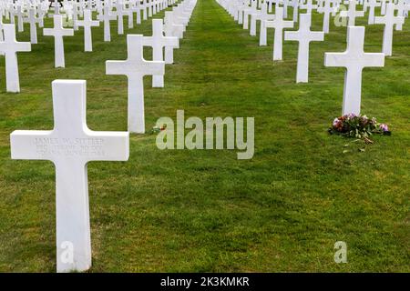 Eine Hommage an Blumen auf dem amerikanischen Kriegsfriedhof, Omaha Beach, Colville-sur-Mer, Calvados, der Normandie, Frankreich. Stockfoto