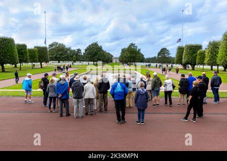 Führung mit einer Gruppe von Besuchern auf dem amerikanischen Kriegsfriedhof, Omaha Beach, Colville-sur-Mer, Calvados, Normandie, Frankreich. Stockfoto