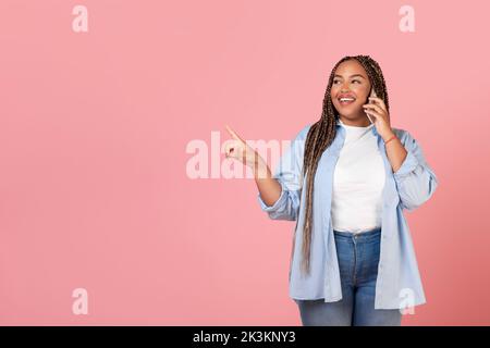 Glückliche Schwarze Frau Im Gespräch Am Telefon Blick Beiseite, Rosa Hintergrund Stockfoto