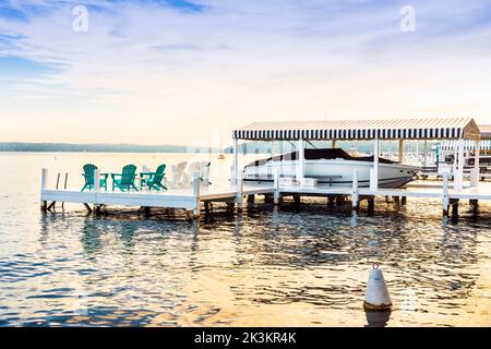 Kleiner hölzerner Pier mit privater Yacht, am frühen Morgen am Genfer See, Wisconsin, Amerika. Stockfoto