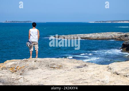 Mann, der von hohen Klippen auf das Meer blickt. Das Rauschen heftiger Wellen auf den Felsen. Raue Wellen des Schwarzen Meeres im Hintergrund. Kocaeli Kefken Pi Stockfoto