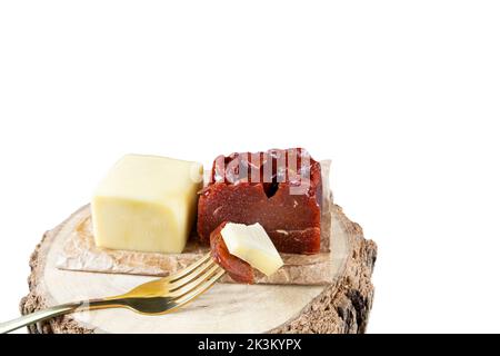 Gabel mit Stücken von Guava süß mit Käse auf einem hölzernen Board white Hintergrund. Stockfoto