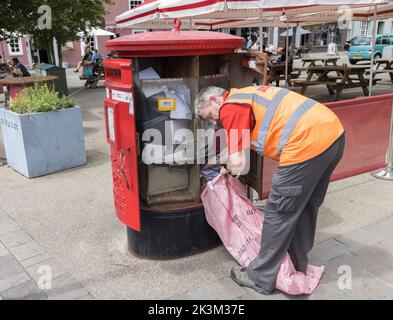 Postbote Leeren der Royal Mail Postbox, Wales, Großbritannien Stockfoto