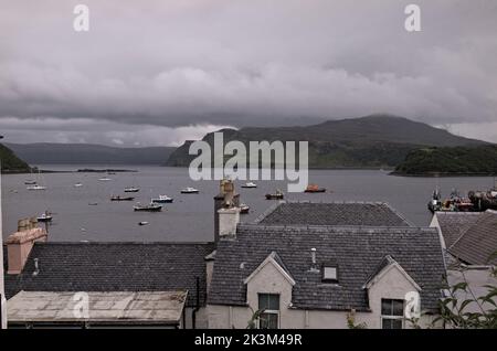 Fischerboote im Hafen von Portree, Loch Portree und Ben Tianavaig in Mist, Isle of Skye, Schottland. Stockfoto