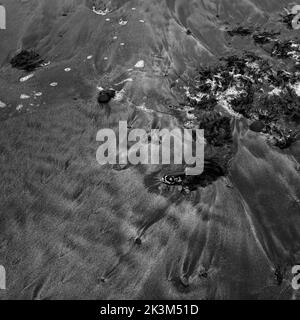 Monochromes Bild des schwarzen Sandstrandes in der Nähe des Campingplatzes Glen Spröde, Loch Spröde, Isle of Skye, Schottland. Stockfoto