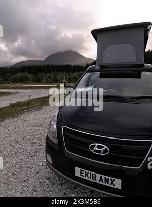 Ein Wohnmobil parkte mit seinem Dach auf dem Camping Skye-Gelände in Broadford mit Beinn na Caillich in Mist Beyond, Isle of Skye, Schottland. Stockfoto