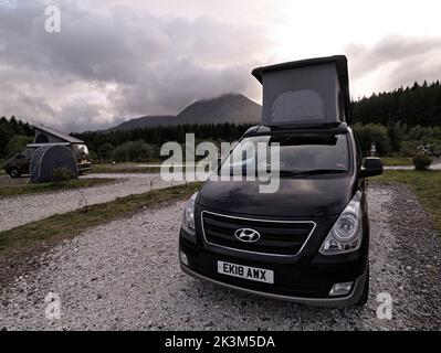 Ein Wohnmobil parkte mit seinem Dach auf dem Camping Skye-Gelände in Broadford mit Beinn na Caillich in Mist Beyond, Isle of Skye, Schottland. Stockfoto