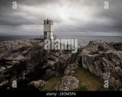 Der Leuchtturm mit Betonweg, der durch gefaltete Felsen am Point of Sleat, Sleat, Isle of Skye, Schottland führt. Stockfoto