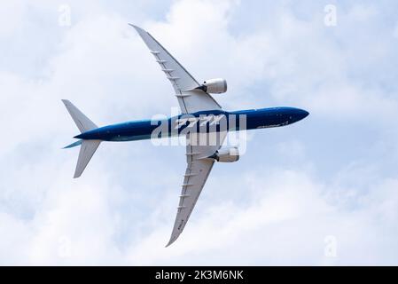 Boeing 777-9, auch bekannt als 777X, Linienflugzeug, das auf der Farnborough International Airshow 2022 gezeigt wird. Drehen mit hohem Winkel. Unterseite Stockfoto