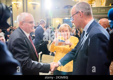 Berlin, Deutschland. 27. September 2022. Friedrich Merz (r), CDU-Bundesvorsitzender, Und Volker Kauder (CDU, l), Vorsitzender des Kuratoriums der Bundeskanzler-Helmut-Kohl-Stiftung, grüßen sich bei der Eröffnung der Bundeskanzlerin Helmut-Kohl-Stiftung in der Friedrichstadtkirche am Gendarmenmarkt vor Angela Merkel (CDU, M), ehemaliger Bundeskanzlerin. Quelle: Christoph Soeder/dpa/Alamy Live News Stockfoto