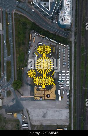 Draufsicht auf das Stadtbild mit modernen Gebäuden und Zirkuszelten, die an sonnigen Tagen in Deutschland in Straßennähe aufgestellt wurden Stockfoto