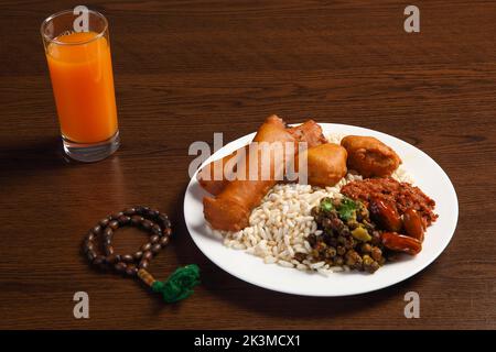 Ramadan Kareem und iftar muslimisches Essen, Urlaubskonzept. Tabletts mit Nüssen und getrockneten Früchten und Laternen mit Kerzen. Stockfoto