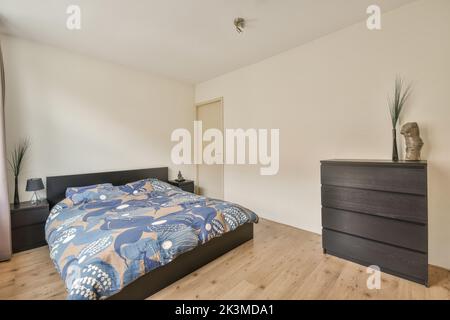 Breites, komfortables Bett mit warmen Decken im trendigen Schlafzimmer der modernen Wohnung Stockfoto