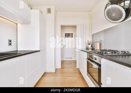 Theken in stilvoller Küche mit modernen Geräten in heller, geräumiger Wohnung Stockfoto