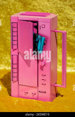 Retro-Kassettenrekorder mit Audiokassette mit unordentlicher Magnetfolie auf gelber Oberfläche im Studio Stockfoto