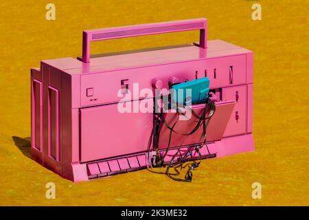 Retro-Kassettenrekorder mit Audiokassette mit unordentlicher Magnetfolie auf gelber Oberfläche im Studio Stockfoto