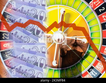 Zwanzig Pfund-Noten auf Roulette-Rad mit Mann hält seinen Kopf in den Händen. Sinkendes Pfund, Glücksspiel, britische Wirtschaft, Inflation, Zinsen, Hypothekenzinsen... Stockfoto