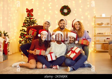 Gruppenportrait von glücklichen jungen Freunden, die zu Hause gemeinsam Neujahrsferien feiern. Stockfoto