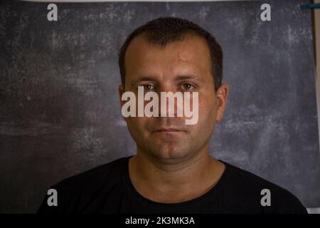 Das Gesicht eines jungen Mannes in einem schwarzen T-Shirt. Stockfoto