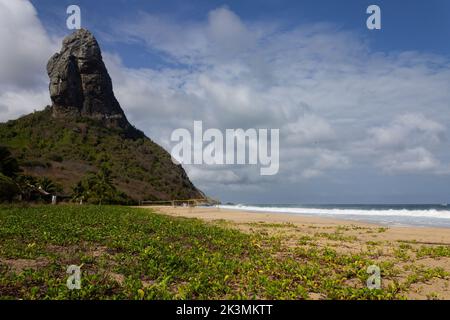 Der Strand Praia da Conceicao in Brasilien mit einem grünen Ufer an einem sonnigen Tag Stockfoto