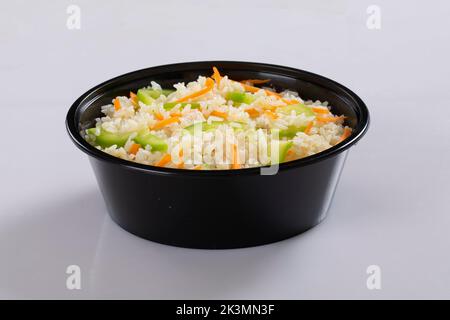 Schezwan Chicken Fried Rice in weißer Schüssel isoliert auf weißem Hintergrund. Szechuan Rice ist ein indochinesisches Gericht mit Paprika, grünen Bohnen und Auto Stockfoto