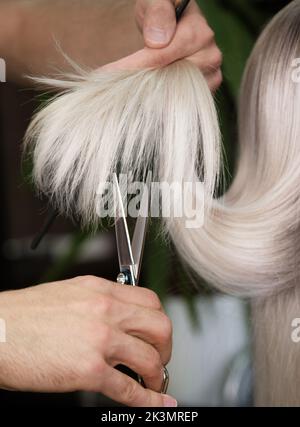 Die junge Frau in einem Friseursalon färbt ihre Haare blond und schneidet Haare Stockfoto