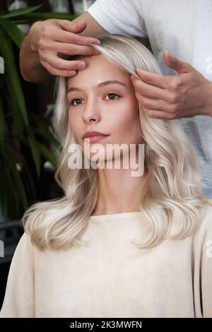 Die junge Frau in einem Friseursalon färbt ihr Haar blond Stockfoto