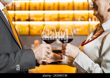 Zwei ältere Menschen, die anstoßen Stockfoto