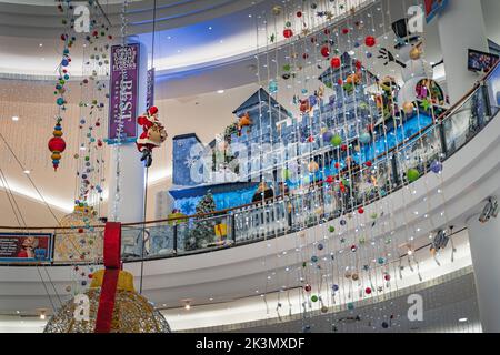 Dublin, November 2019 Santa Claus klettert auf einem Seil, Weihnachtskugeln Schneemann und Dekorationen im Jervis Shopping Centre. Santa Grotte oder Winterburg Stockfoto