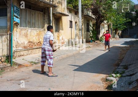 Ein paar junge Jungs spielen Cricket in der Straße von Bengaluru, Indien Stockfoto