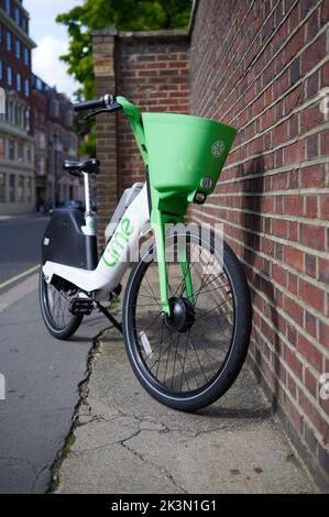 London UK Sep 24 2022 - Lime-E Fahrrad auf der Londoner Straße neben der roten Backsteinmauer Stockfoto