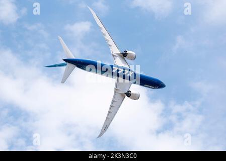 Boeing 777-9, auch bekannt als 777X, Linienflugzeug, das auf der Farnborough International Airshow 2022 gezeigt wird. Drehen mit hohem Winkel. Unterseite Stockfoto