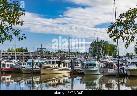 Motorboote liegen in der Marina. Bootspromenade für Touristen und ein Boot. Motorboote und Yachten stehen in der Nähe der hölzernen Pier im Fluss oder See-Vancou Stockfoto