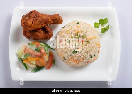 Schezwan Chicken Fried Rice in weißer Schüssel isoliert auf weißem Hintergrund. Szechuan Rice ist ein indochinesisches Gericht mit Paprika, grünen Bohnen und Auto Stockfoto