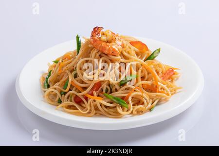 Schezwan Noodles oder Szechwan Gemüse Hakka Noodles oder Chow Mein sind beliebte indochinesische Rezepte, die in einer Schüssel oder einem Teller mit Holzstäbchen serviert werden Stockfoto